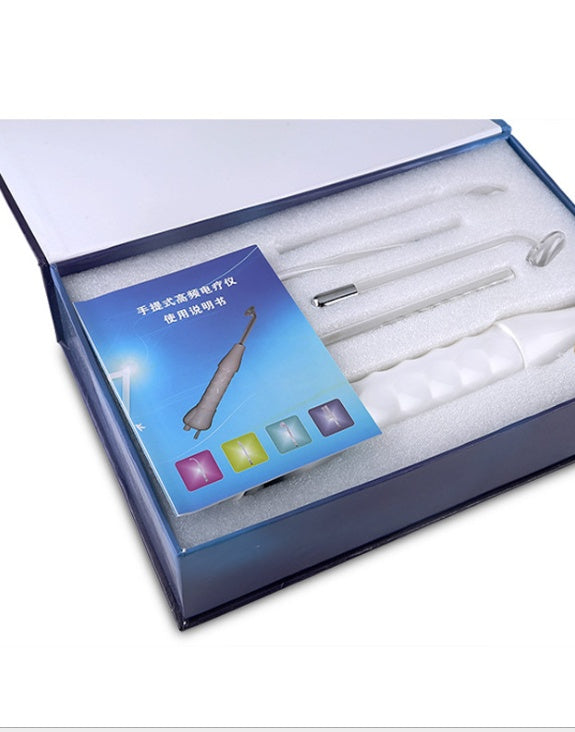 Open blue box containing handheld high frequency skin therapy wand with glass electrodes and instruction manual