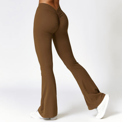 Rear view of brown high-waist bootcut fitness pants with scrunch detail, worn with white sneakers