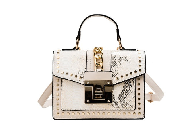 Beige alligator texture crossbody bag with gold studs, chain detail, and front lock clasp