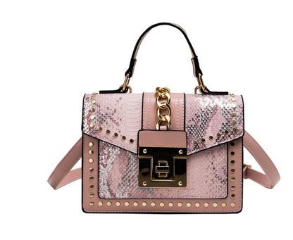 Pink alligator texture shoulder bag with studs and gold chain detail, compact women's crossbody handbag