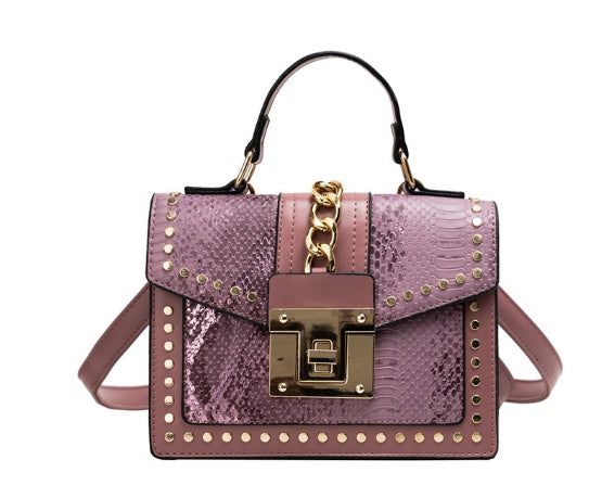 Purple snakeskin textured handbag with gold chain detail and stud accents, top handle and straps
