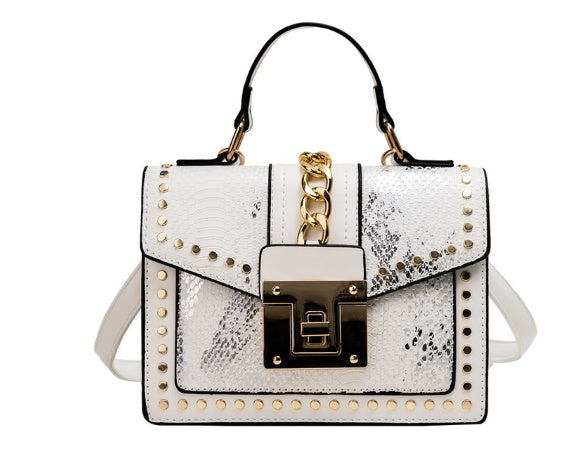 white alligator texture crossbody bag with gold studs, chain detail, and top handle