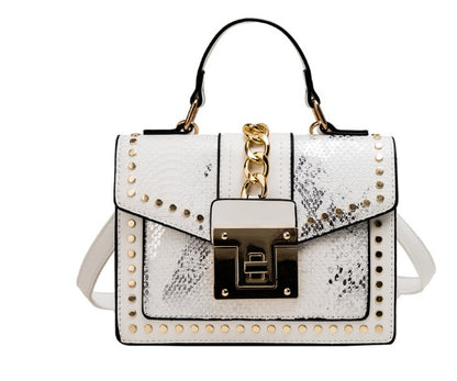 white alligator texture crossbody bag with gold studs, chain detail, and top handle