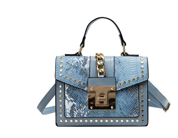 blue alligator leather crossbody bag with gold studs and chain detail