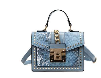 blue alligator leather crossbody bag with gold studs and chain detail