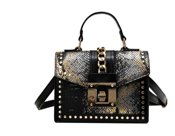 black leather handbag with gold chain detail, stud accents, and textured snakeskin pattern