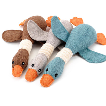 Three plush duck dog toys in brown, gray, and blue fabric with orange beaks and wings on white background