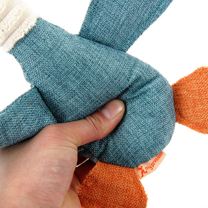 Hand squeezing blue and orange plush duck dog toy with durable fabric and squeaky feature