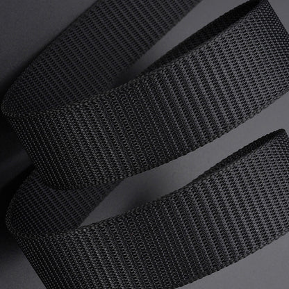 Black durable canvas belt with woven texture close-up on gray background