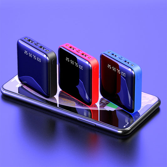 Three mini portable power banks in black, red, and blue with digital battery displays on a smartphone