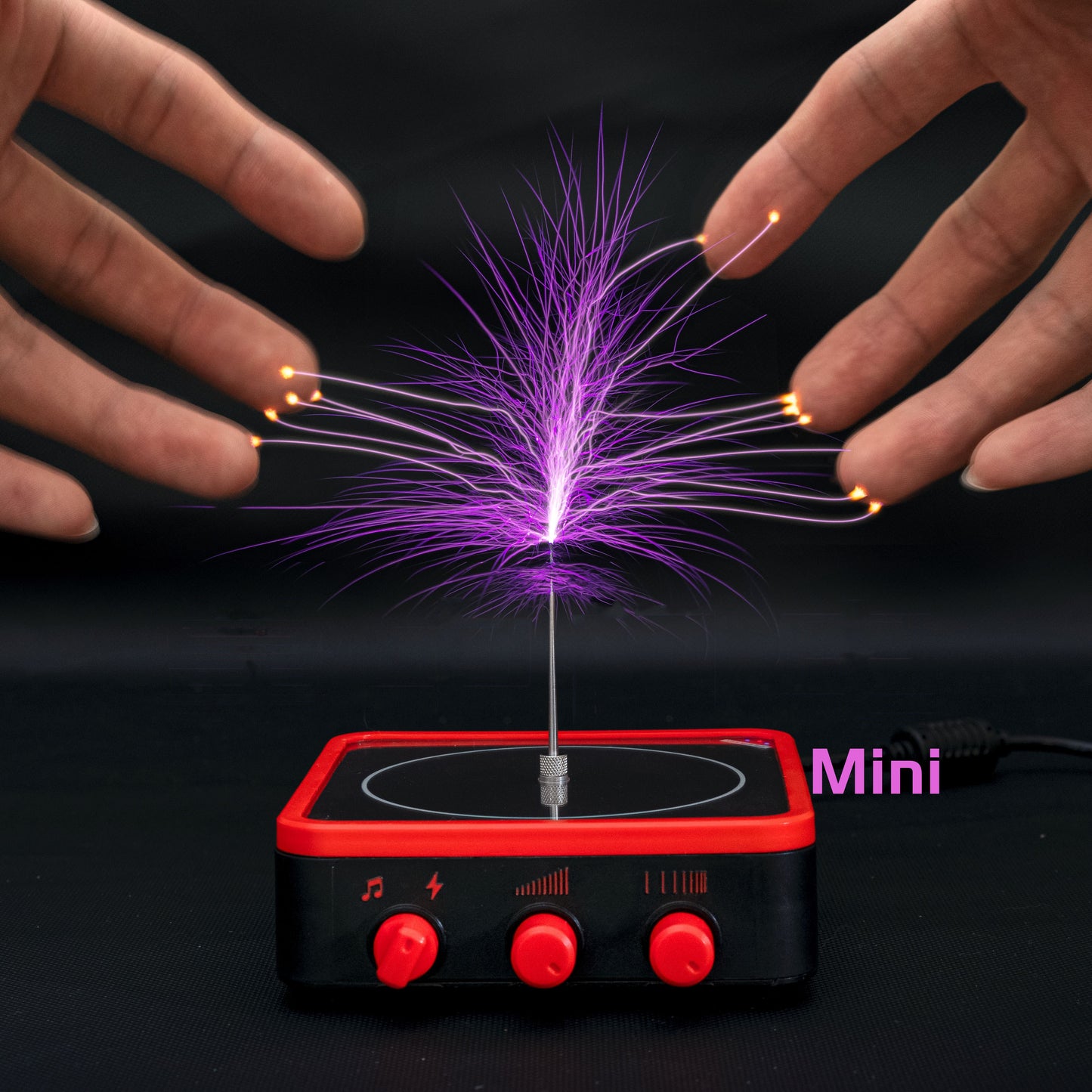 Mini Tesla coil physics toy with purple electric arcs touching fingertips, black and red base controls