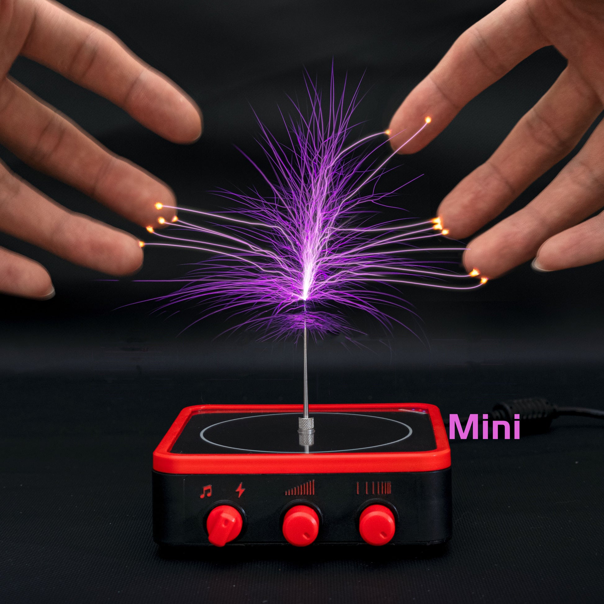 Mini Tesla coil physics toy with purple electric arcs touching fingertips, black and red base controls
