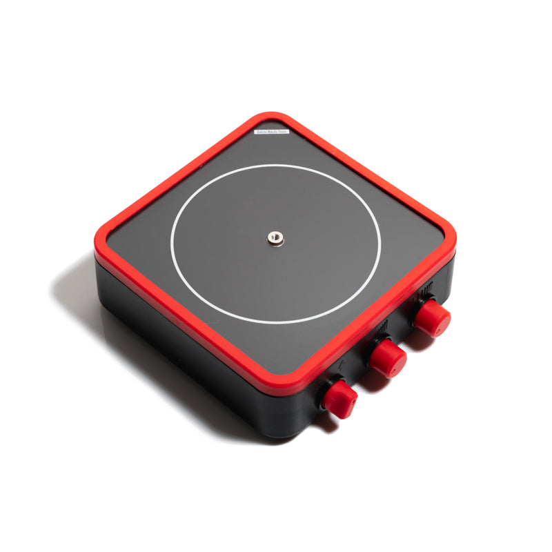 Square black physics toy with red border and knobs, featuring a central circular pattern