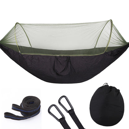 Black camping hammock with green mosquito net, straps, carabiners, and carrying bag