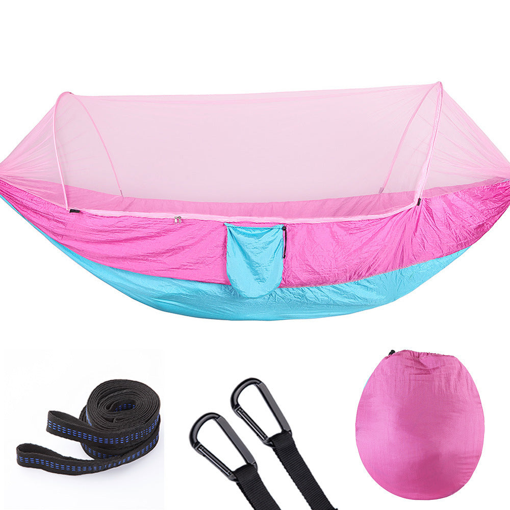 Pink and blue camping hammock with mosquito net, straps, carabiners, and carrying bag