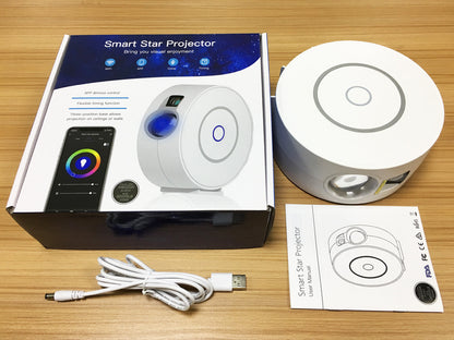 Smart Star Projector box, white round star projector lamp, USB cable, and user manual on wooden surface