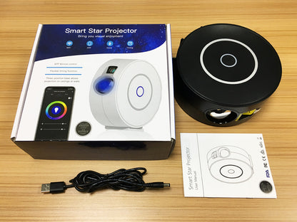 Trendoligy Smart Star Projector black unit with USB cable, user manual, and product box on wood table