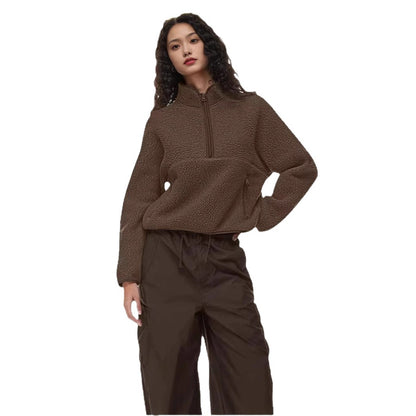 Woman wearing brown half-zip loose lamb wool sweatshirt and dark brown pants on white background