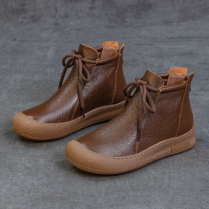 Brown women's leather ankle boots with textured soles and lace-up design on gray background