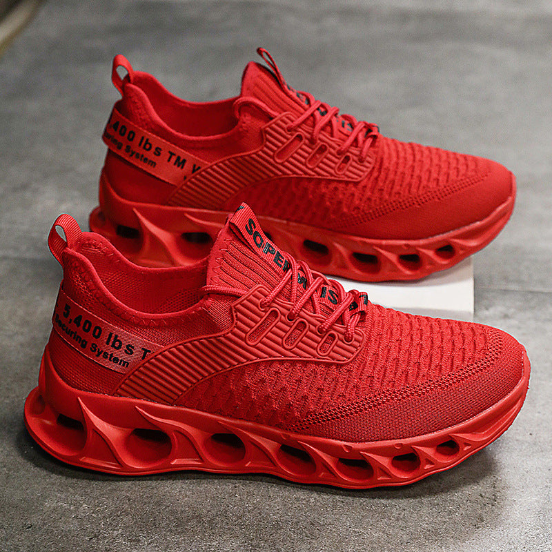 Pair of vibrant red breathable mesh men's running shoes with hollow segmented soles on gray surface