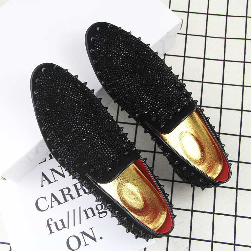 Men's black pointed-toe loafers with black studs and gold insoles on grid and text background