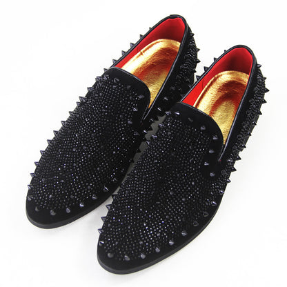 Men's black loafers with pointed toes, studded spikes, and gold-red interior lining