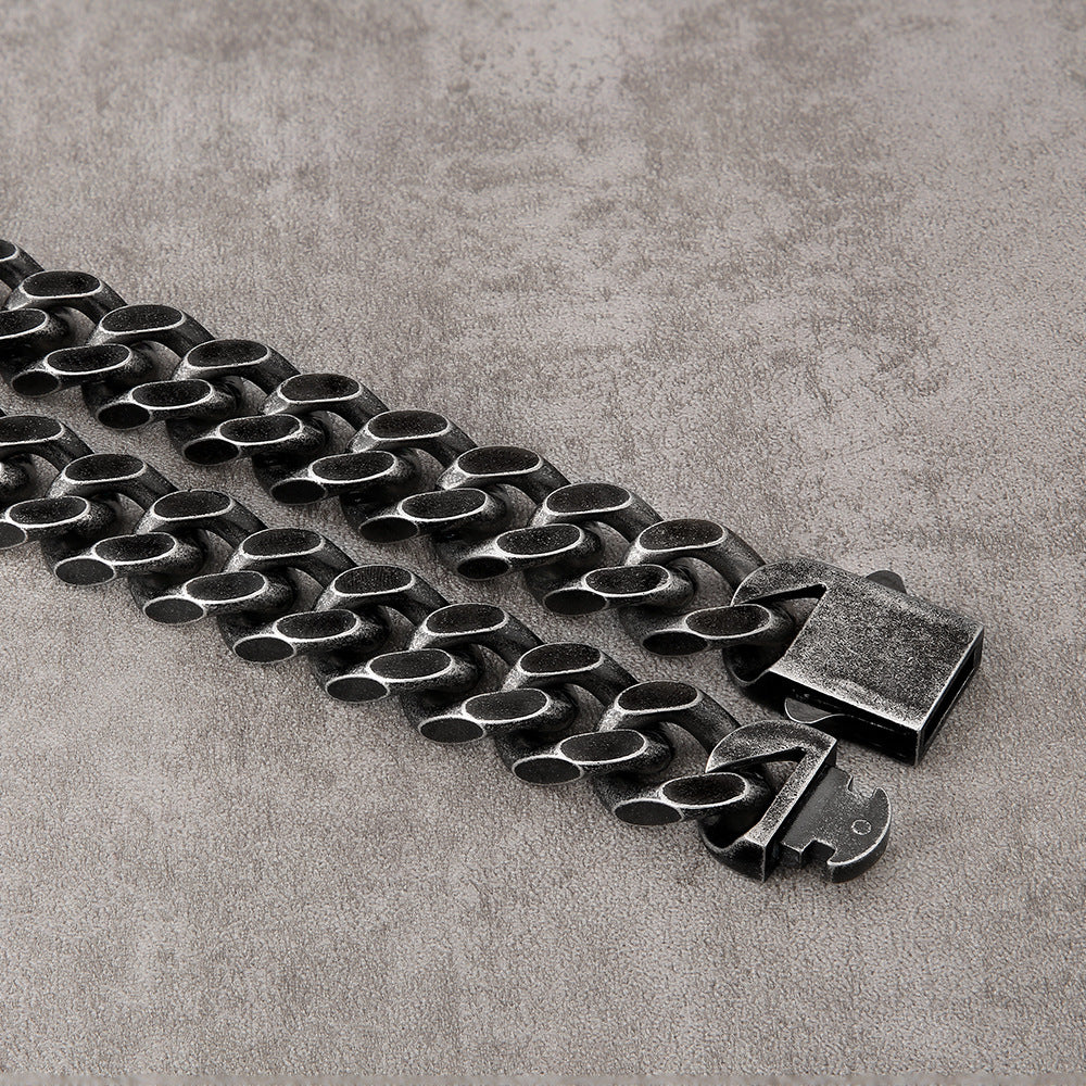 Black titanium steel Cuban link chain necklace with durable geometric design on gray surface