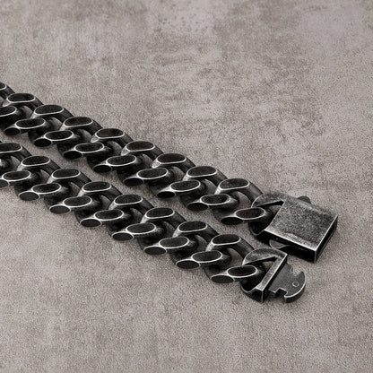 Black titanium steel Cuban link chain necklace with durable geometric design on gray surface
