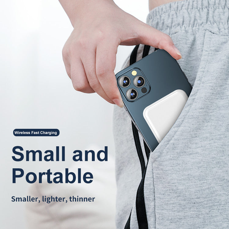 Hand placing black iPhone with white magnetic wireless charging power bank into gray sweatpants pocket