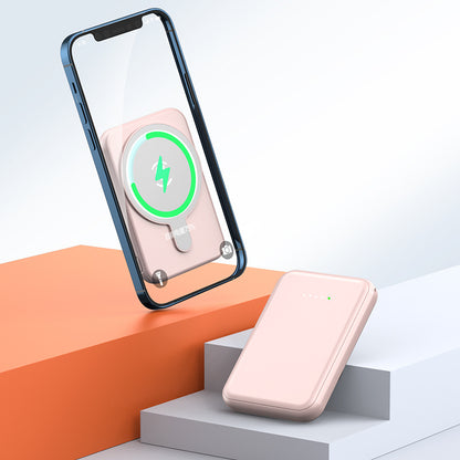 Pink magnetic power bank charging iPhone wirelessly on orange and gray steps