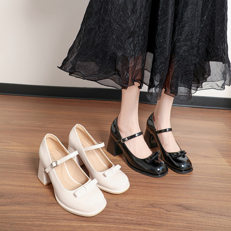 Women's patent leather Mary Jane shoes with chunky heels in black and beige on wooden floor