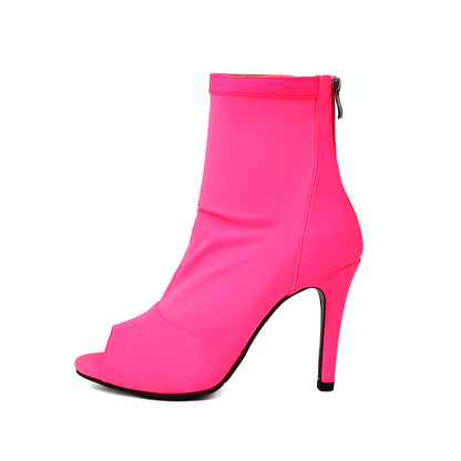 Bright pink women's stiletto ankle boot with peep toe and back zipper on white background