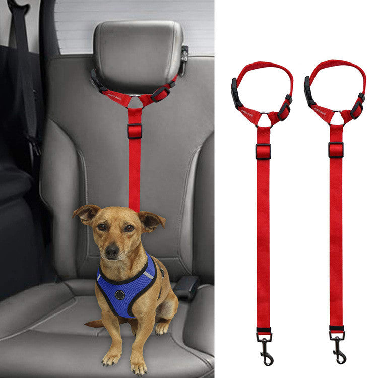 Red adjustable dog safety restraint attached to car headrest with small brown dog in blue harness seated on car seat