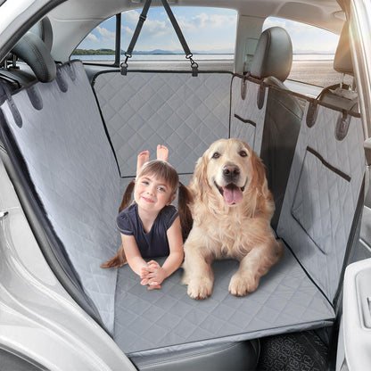 Child and golden retriever sitting on waterproof gray car seat cover in car backseat