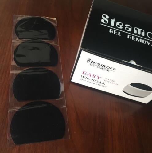 Steam Off gel nail remover machine box and four black gel remover pads on wooden surface