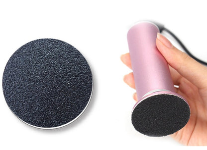 Hand holding pink rechargeable electric callus remover with black abrasive surface for pedicure