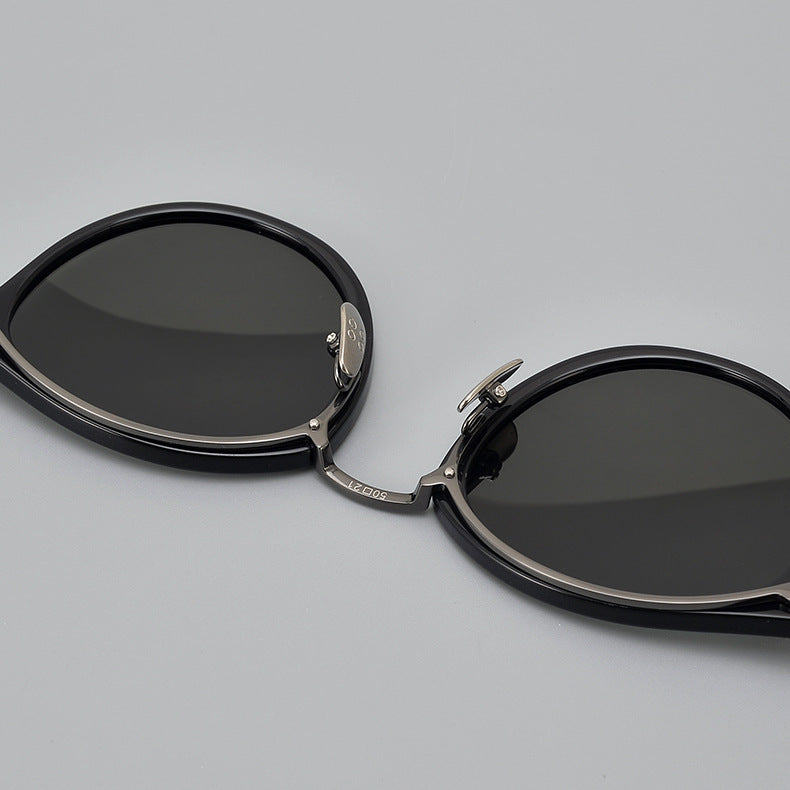 Black round frame titanium sunglasses with polarized dark lenses and silver nose pads on gray background