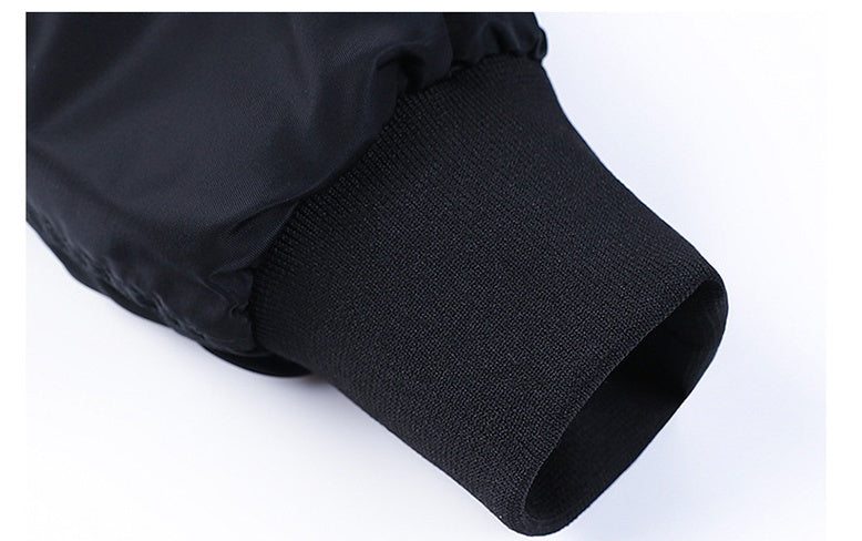 Close-up of black aviator jacket sleeve with elastic ribbed cuff on white background