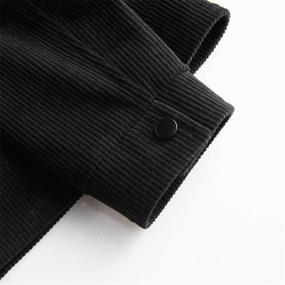 Close-up of black corduroy jacket sleeve with buttoned cuff on white background