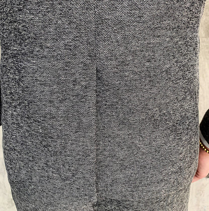 Close-up of men's black slim fit suit jacket with herringbone pattern and single button closure