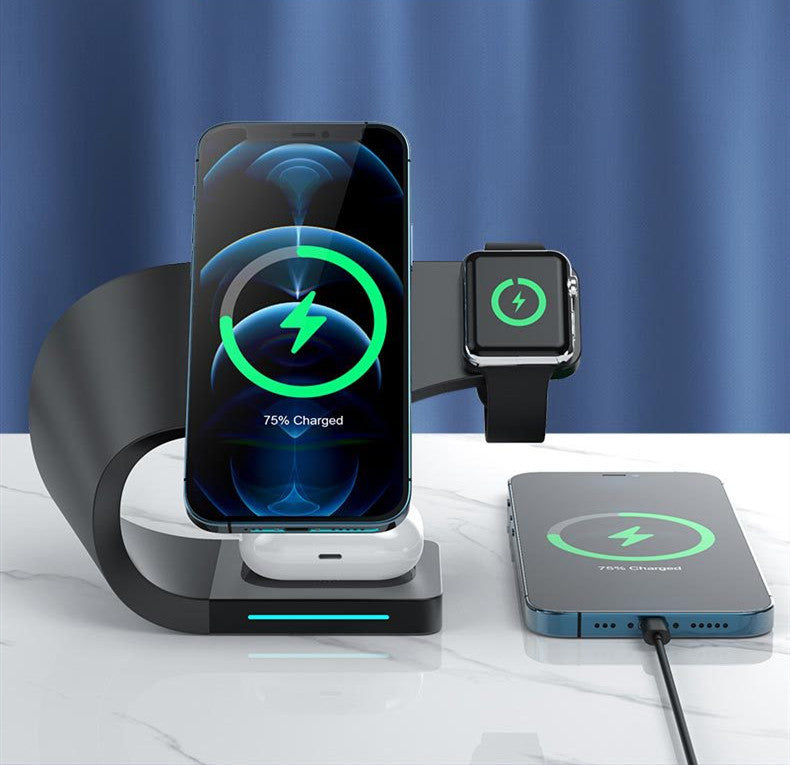 Black magnetic wireless charger stand charging smartphone, smartwatch, and earbuds on white surface