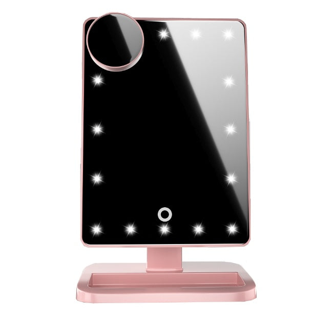 Black makeup mirror with LED lights and round magnifying mirror on pink stand with tray