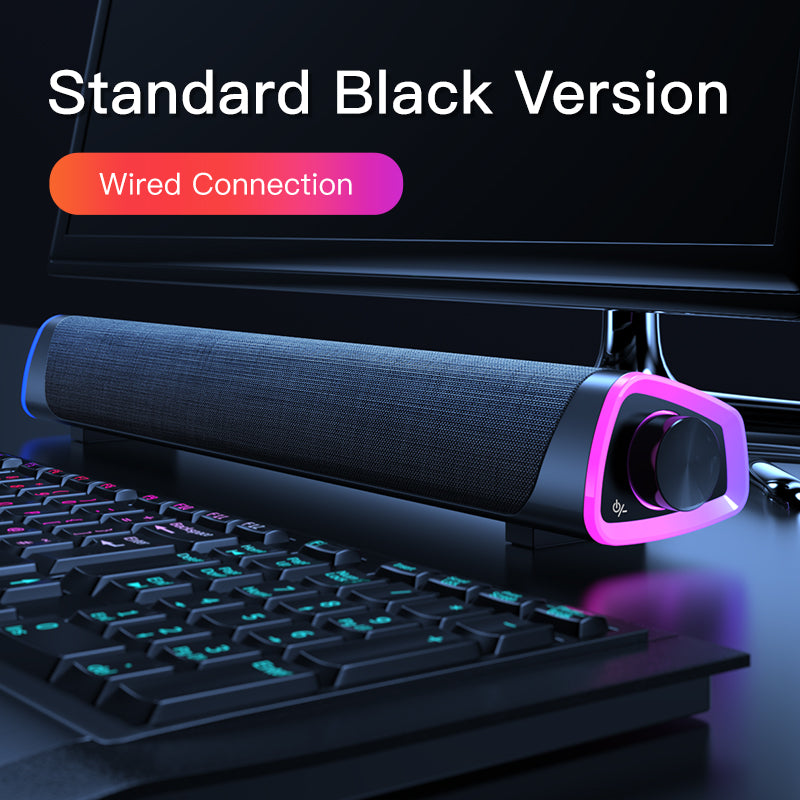 Standard black wired soundbar speaker with volume knob and RGB lighting on desktop keyboard setup