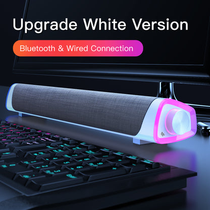 White Bluetooth and wired desktop soundbar with RGB lighting on computer desk with keyboard
