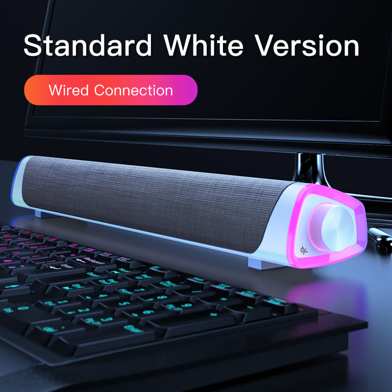 White wired soundbar with pink LED light on computer desk, placed in front of monitor and keyboard