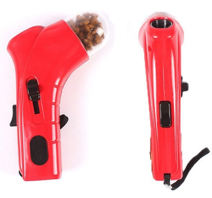 Red interactive pet treat launcher with ergonomic grip, loaded with brown pet treats