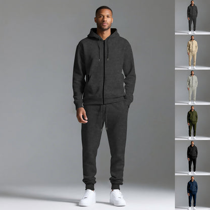 Man wearing black hooded sportswear cotton blend tracksuit set with white sneakers on gray background
