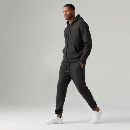Man wearing black hooded zipped sportswear cotton blend tracksuit set with white sneakers on light background