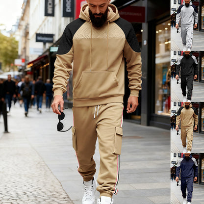 Man walking in beige and black color-block hoodie with matching cargo sweatpants and white sneakers on city street