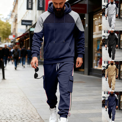 Man wearing navy blue and gray color block hoodie with navy cargo sweatpants walking on city street